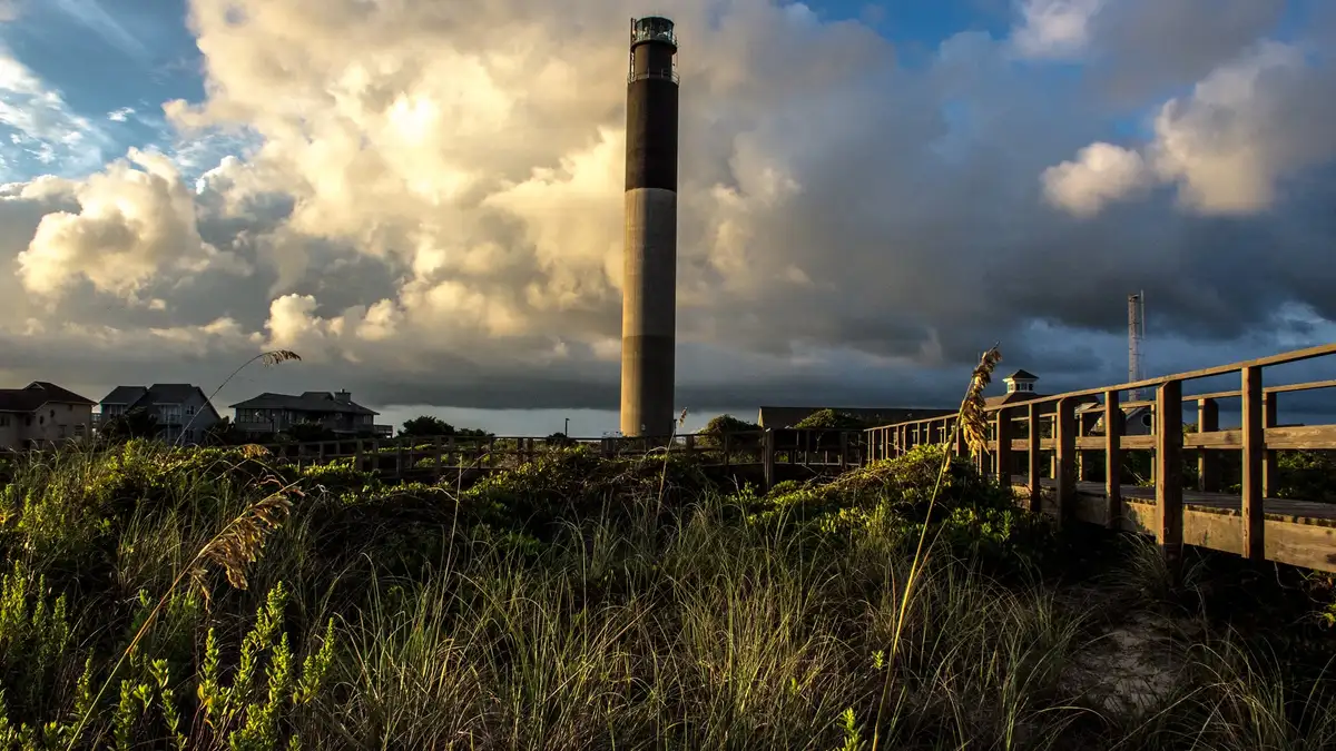 Oak Island Lighthouse from the dune boardwalk, storm cloud behind