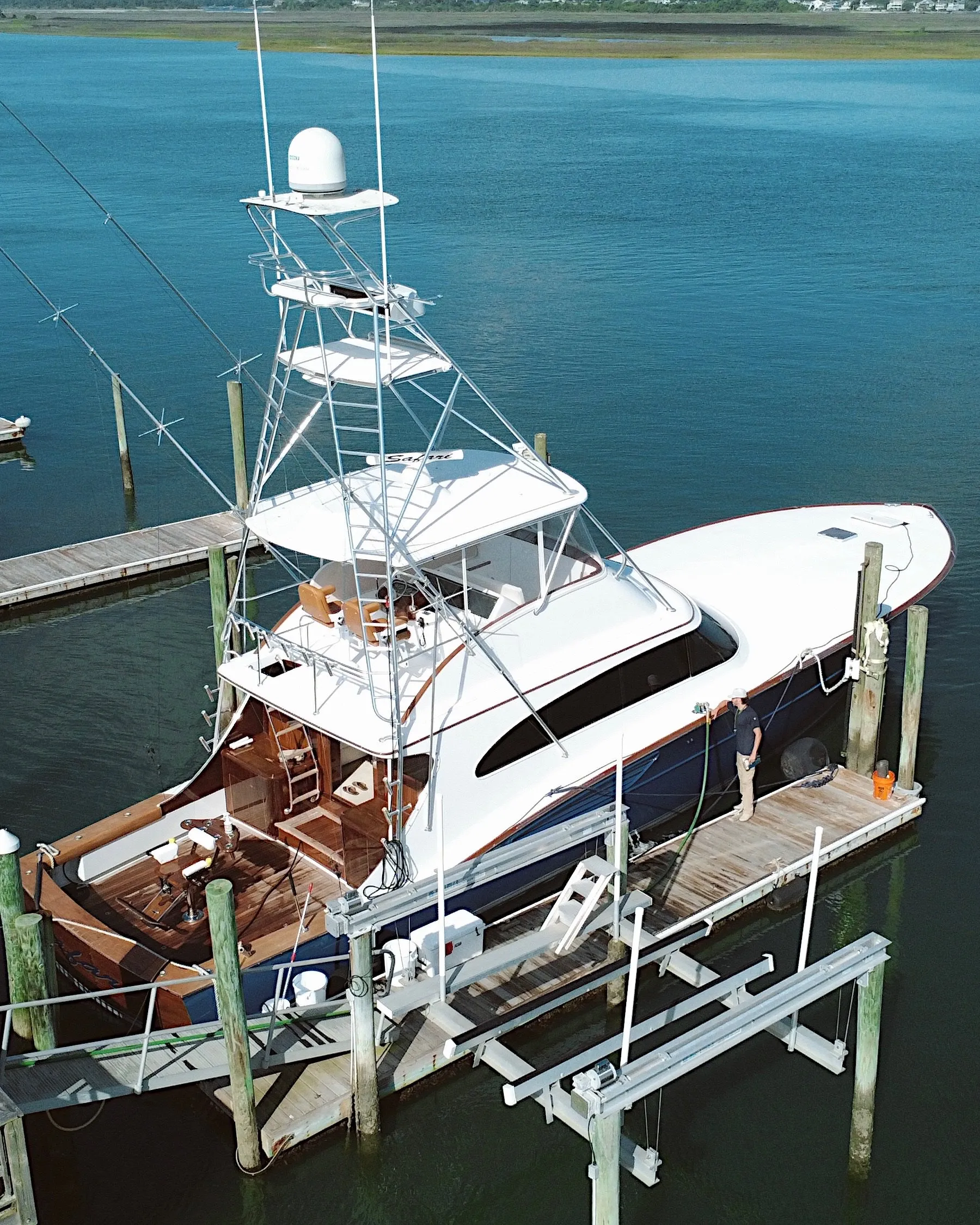 A Fuel Wave crew member on the dock with the hose, beside a sportfisher tied up alongside, seen from above