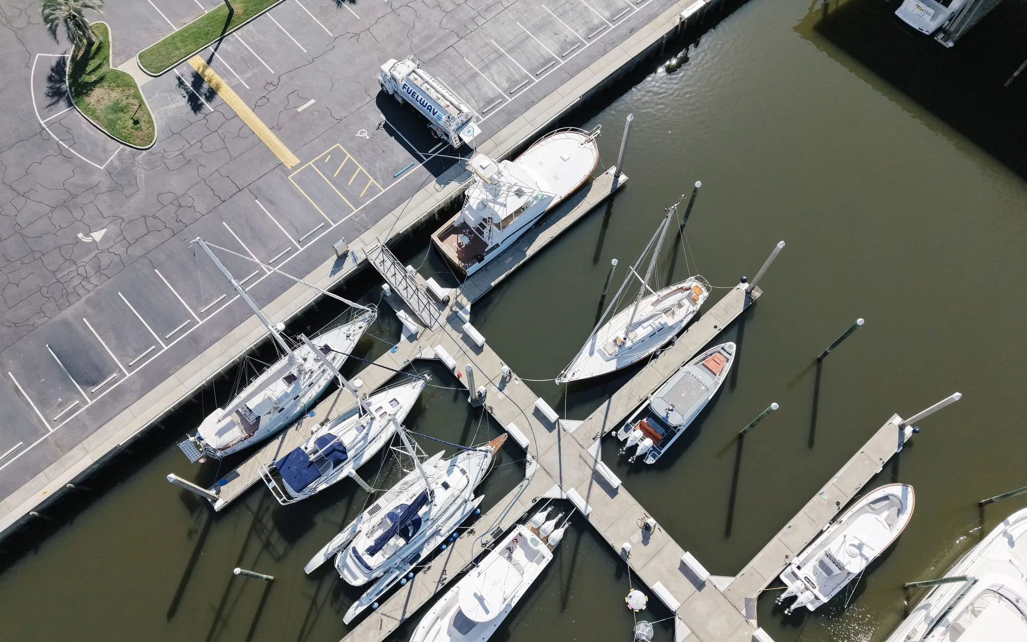 The Fuel Wave tanker parked at the head of a marina dock, with sailboats and sportfishers in the slips, seen from above