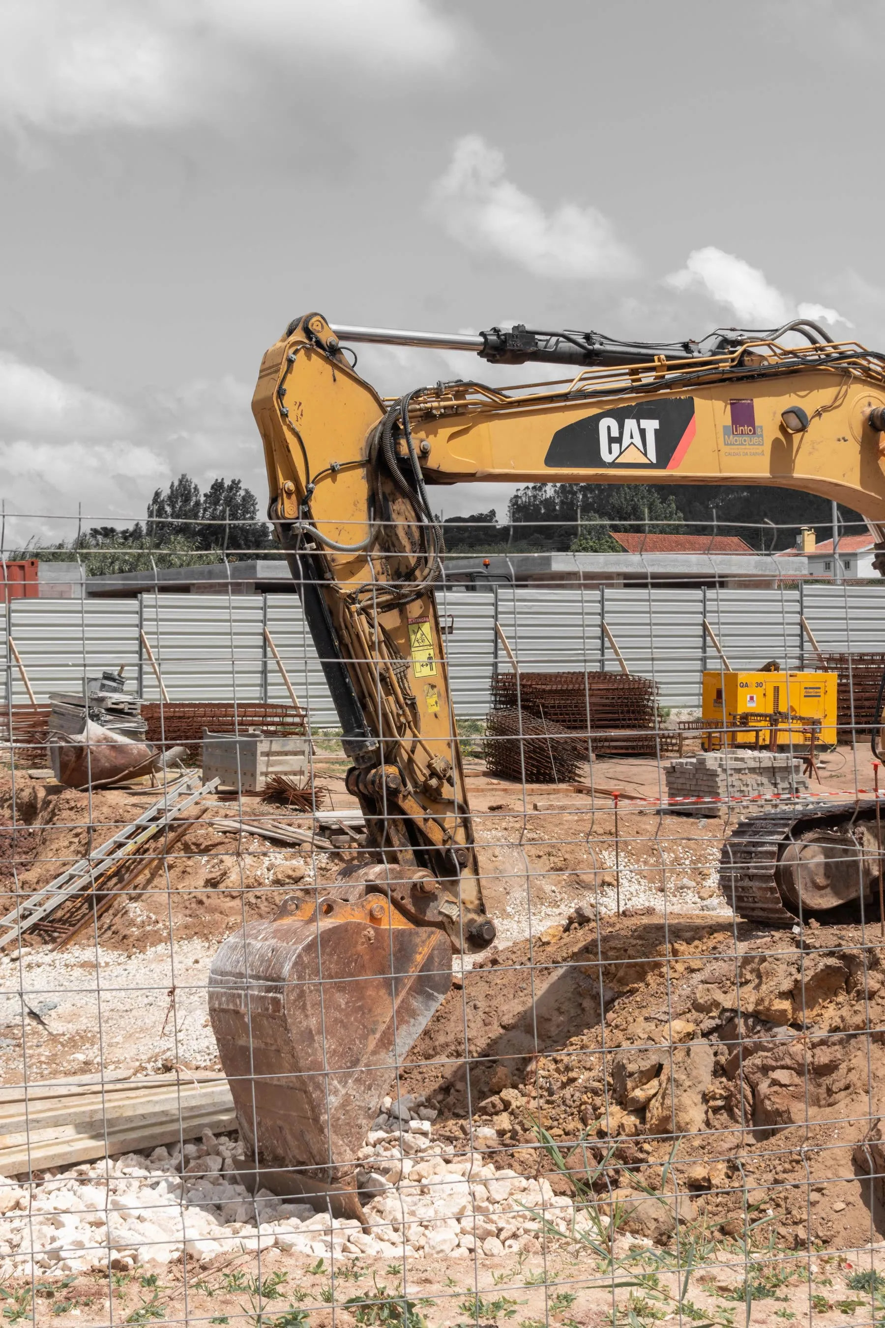 A tracked excavator working over broken ground on a construction site