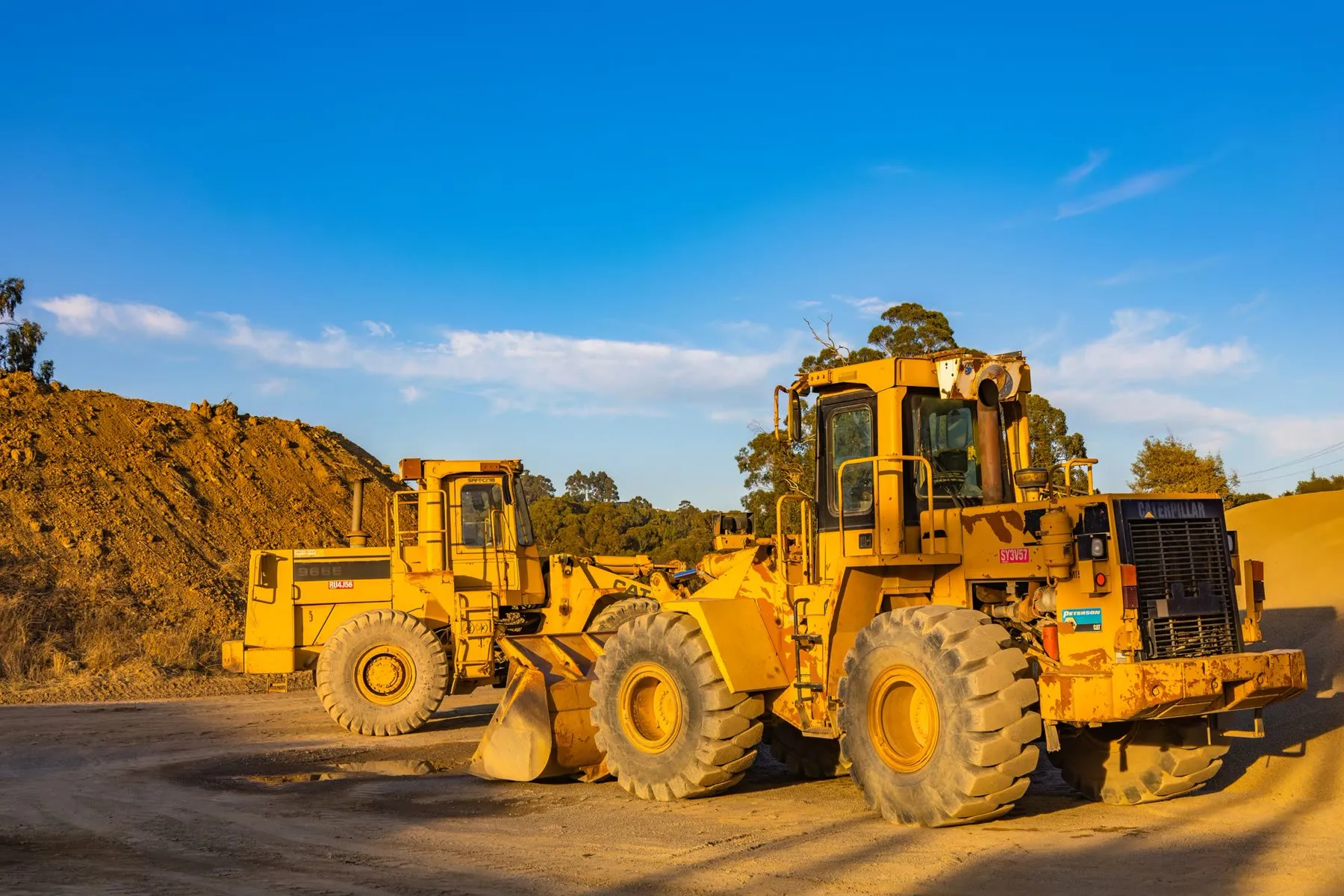 Wheel loaders parked together at the edge of a working site